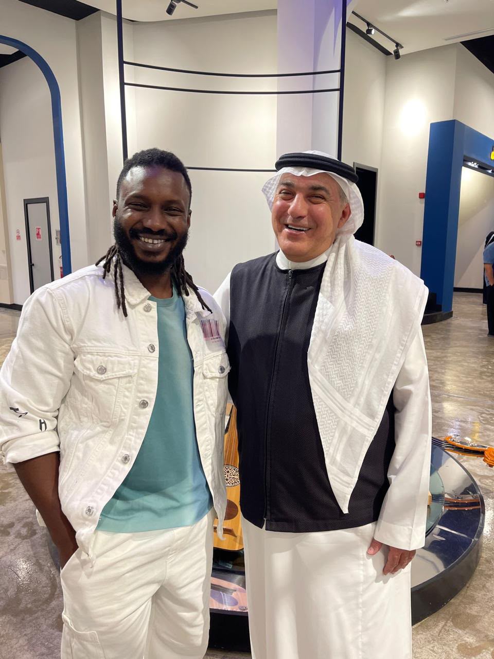 Mazin Kurdi standing with the artist Hamza Hawsawi.