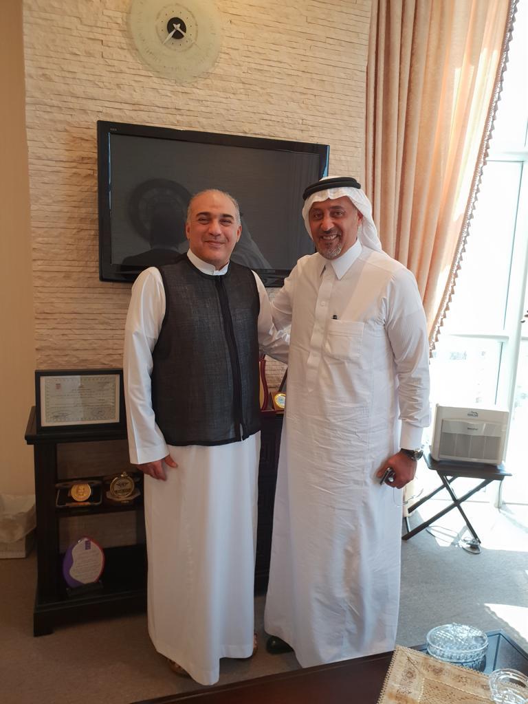 Mazin Kurdi standing with Mr. Hussein Shobokshi in an office.