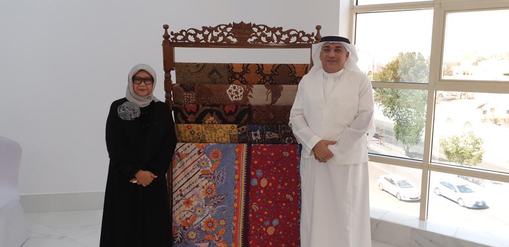 Mazin Kurdi with the Minister of Foreign Affairs of Indonesia beside a decorated screen.